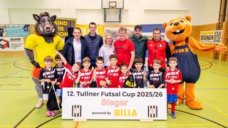 Eine Gruppe junger Fußballspieler, Maskottchen und Erwachsene posiert für ein Foto beim 12. Tullner Futsal Cup 2025/26.