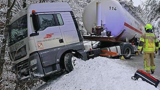 Ein Lkw mit der Nummer 114 ist im Schnee verunglückt, mit den vorderen Rädern in der Luft.