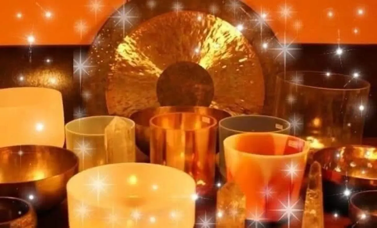 Verschiedene goldene und orangefarbene Schalen und Tassen sind vor einem orangefarbenen Hintergrund mit Sternen und Lichteffekten angeordnet. Ein goldener Gong mit schimmernder Oberfläche ist zentral platziert.