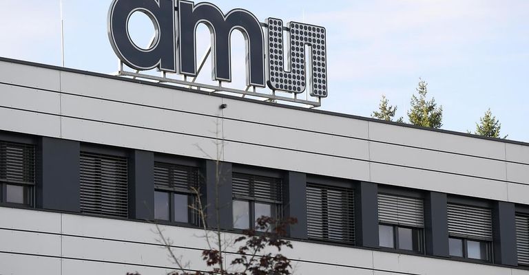 A building with a large sign reading 'amn' on top. The building has multiple windows and a tree is visible behind it.