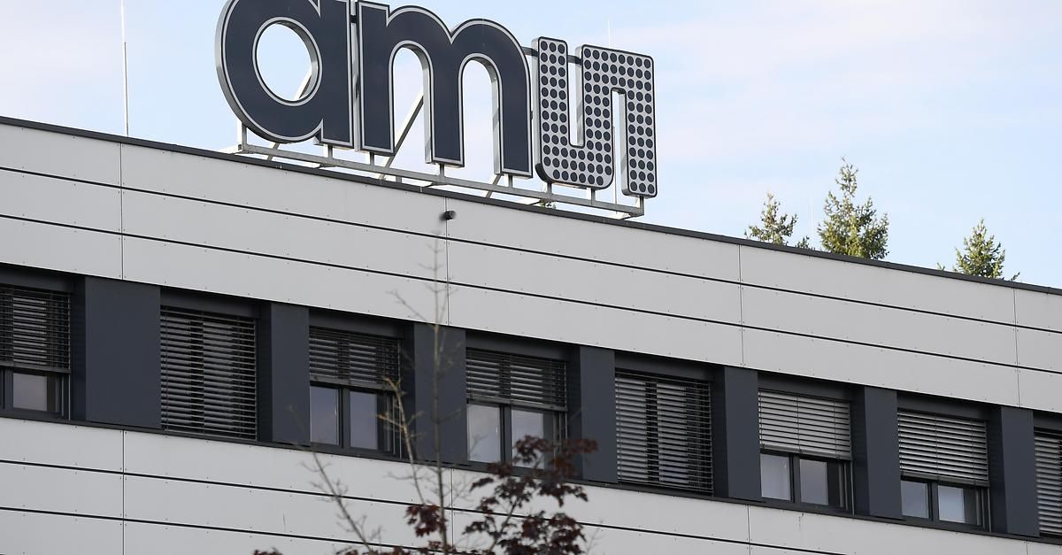 A building with a large sign reading 'amn' on top. The building has multiple windows and a tree is visible behind it.