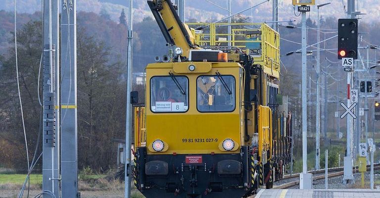 Ein gelber Zug mit einem Kran auf dem Dach steht auf einem Bahngleis. Die Nummer 8 ist auf der vorderen Scheibe zu sehen.