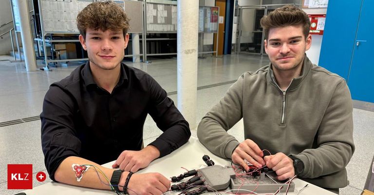 Zwei Männer in einem Labor, einer lächelt und der andere arbeitet an einer Maschine mit Kabeln.