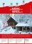 Eine Winterszene mit einer schneebedeckten Hütte und einem kleinen Haus. Ein Flagge steht im Schnee, und es gibt Bänke und Bäume drumherum. Der Himmel ist klar.