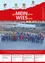 Ein Gruppenfoto von Menschen in Winterkleidung, die in einer Reihe auf einer Straße stehen. Im Hintergrund steht ein roter Banner mit weißem Text, der 'ge MEIN sam WISEuell' lautet. Im Hintergrund sind geparkte Autos und ein Gebäude zu sehen.