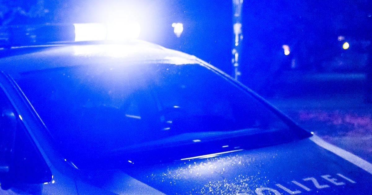 Ein Polizeiauto mit eingeschaltetem Licht steht in einem dunklen Bereich. Das Wort 'POLIZEI' ist auf der Seite sichtbar.