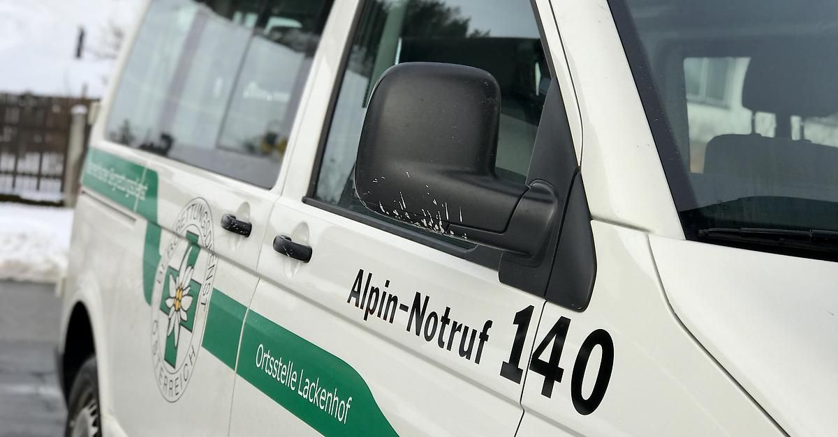 Nahaufnahme eines weißen und grünen Fahrzeugs mit den Worten 'Alpin-Notruf 140' und einem Logo auf der Tür.