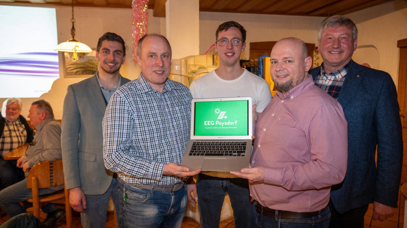 Fünf Männer stehen in einem Raum, einer von ihnen hält einen Laptop mit dem Bildschirmtext EEG Poysdorf.