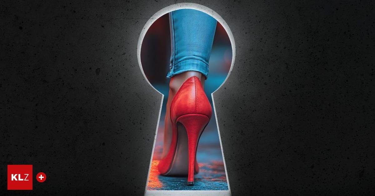 A person wearing blue jeans and red high heels is stepping through a keyhole.