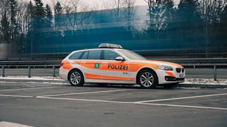 A police car with the number 58 08 is parked in a parking lot with blurred background.