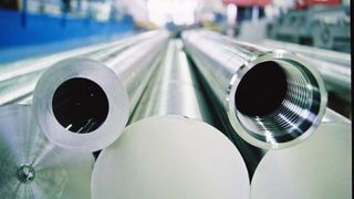 Nahaufnahme mehrerer Metallrohre in einer Fabrikumgebung. Einige Rohre haben offene Enden, andere sind versiegelt.