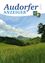 Die Titelseite zeigt ein landschaftliches Bild eines Grasfelds unter einem blauen Himmel mit Wolken, Bergen in der Ferne und einem Wappen oben.