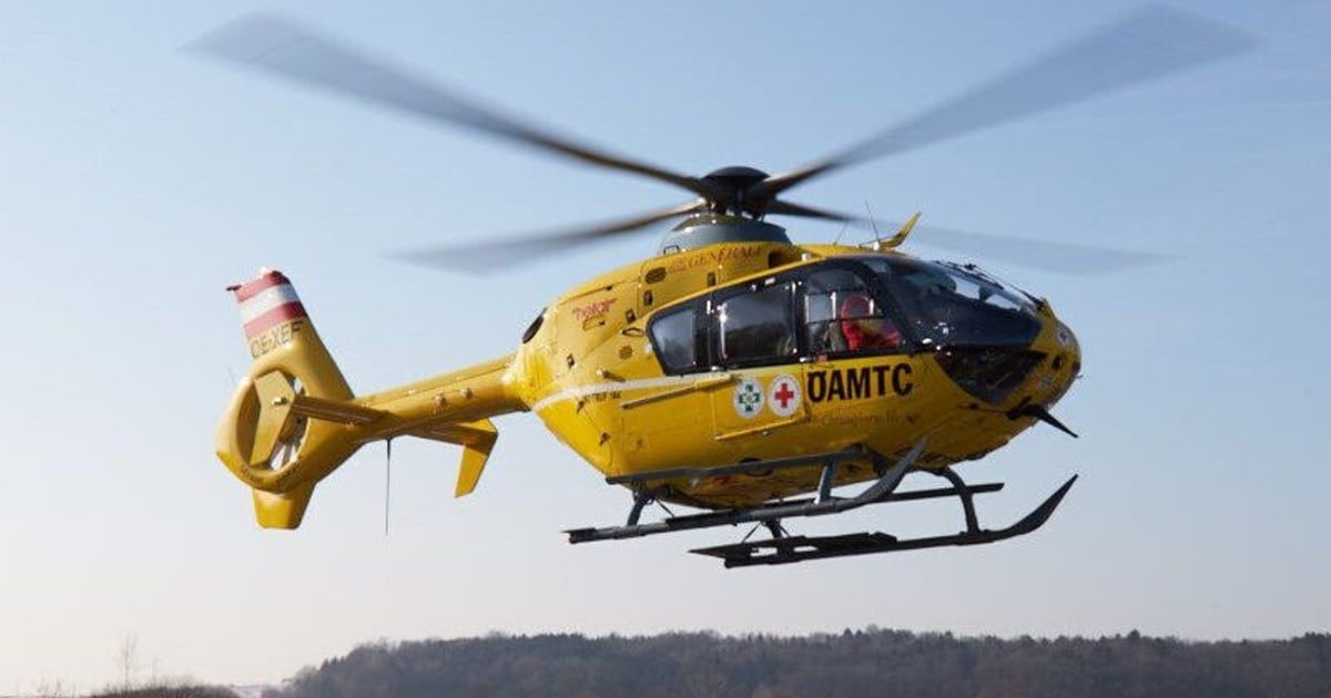 Ein gelber Hubschrauber mit rotem Kreuz und den Buchstaben 'OAMTC' fliegt in der Luft.