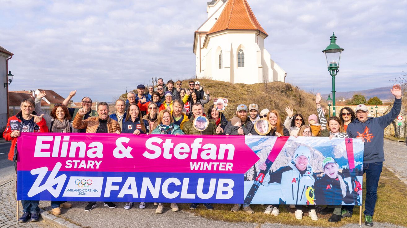Eine Gruppe von Menschen posiert mit einem Banner vor einer Kirche und zeigt ihre Unterstützung für Lara und Stefan Winter.