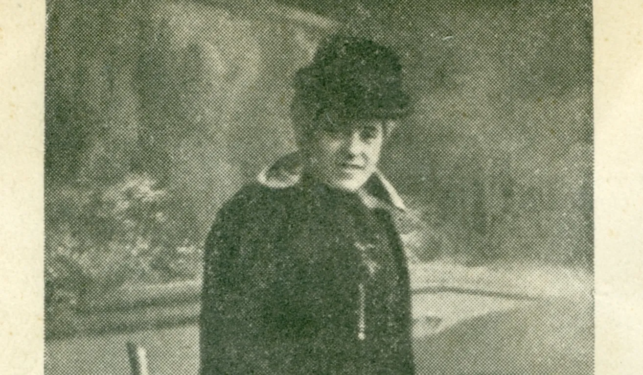 Ein altes Foto einer Person, die Hut und Jacke trägt. Die Person hat einen ernsten Ausdruck.