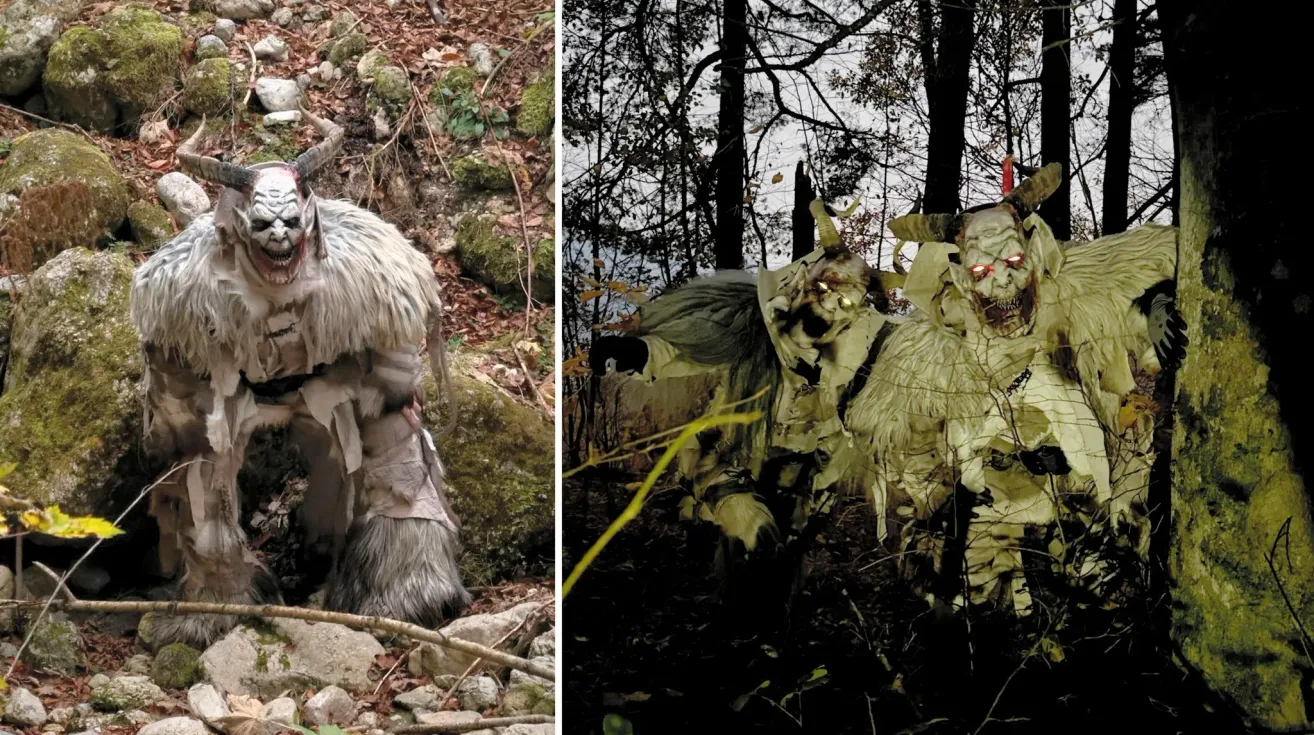 Eine Person in einem pelzigen Kostüm mit Hörnern steht auf einer felsigen Oberfläche. Die Umgebung ist mit abgefallenen Blättern und Moos bedeckt.