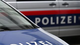 Eine Nahaufnahme eines blauen Polizeiwagens mit dem Wort POLIZEI auf der Front auffällig angebracht.