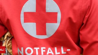 Eine rote Jacke mit einem weißen Kreuzsymbol und dem Wort NOTFALL in weißen Buchstaben.