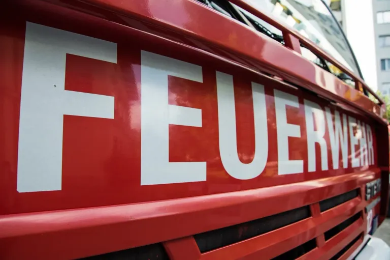 A close-up view of the word 'FEUER' in white on a red background, likely from a fire truck.