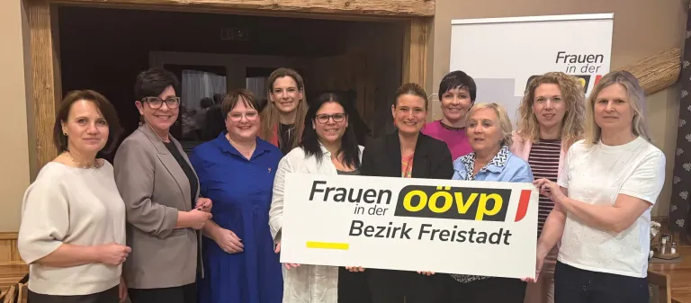 Sechs Frauen lächeln und posieren für ein Foto. Sie halten ein weißes Schild mit gelbem Text, auf dem Frauen oovp im Bezirk Freistad steht.
