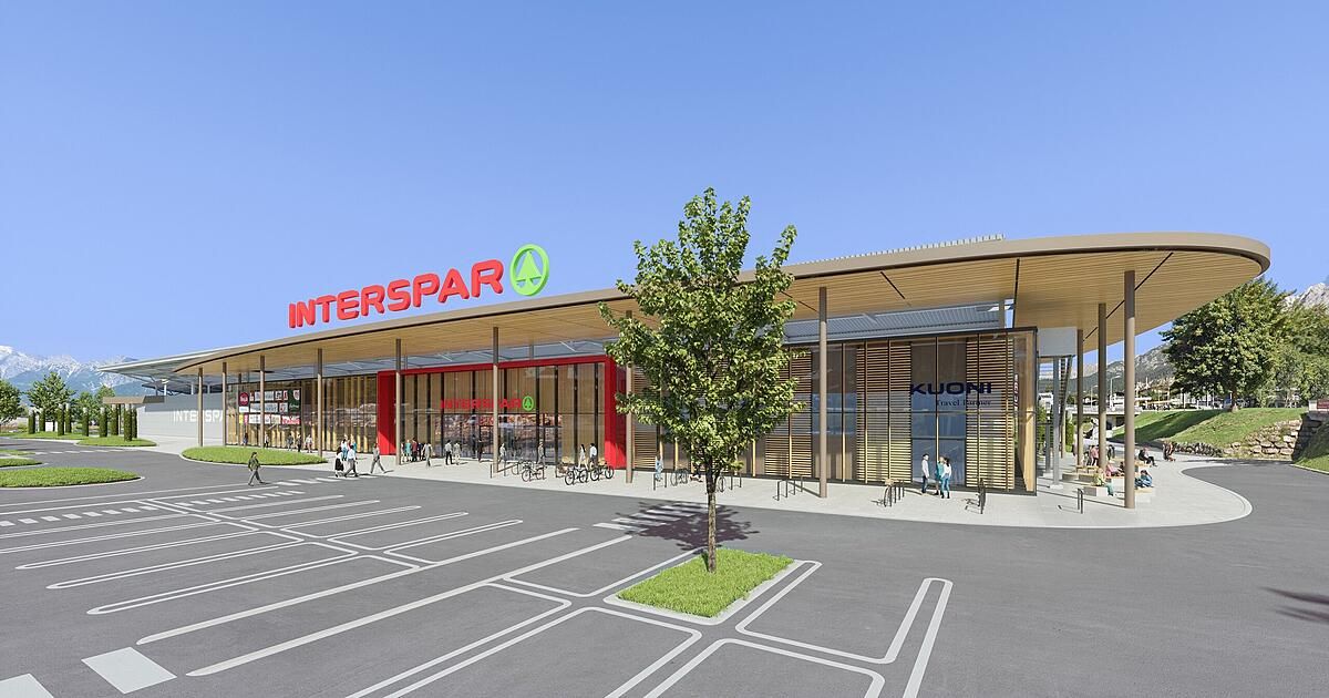 Artistic rendering of the exterior of an Interspar store. The store features a modern design with a green tree in the foreground.
