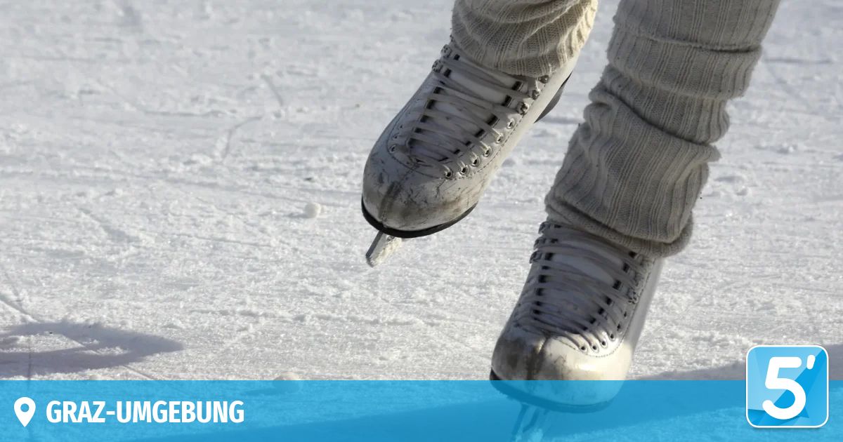 A person in ice skates is jumping on a snowy surface, wearing thick winter clothing.