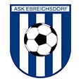 The ASK Ebreichsdorf logo features a shield design with blue and white stripes. A soccer ball is centrally placed on the shield, with the club name 'ASK EBREICHDORF' written above it.