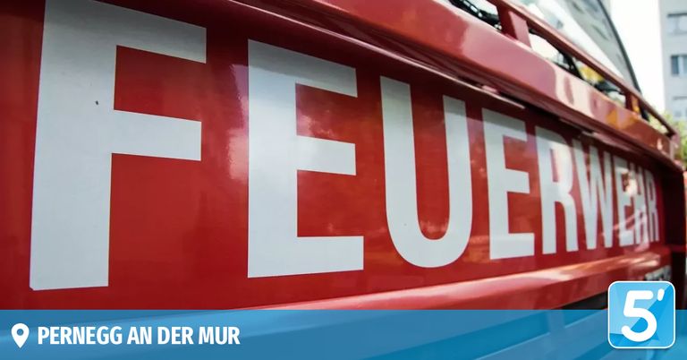 Ein Nahaufnahme des Wortes 'FEUER' in weiß auf rotem Hintergrund, wahrscheinlich von einem Feuerwehrfahrzeug. Der Text 'AN DER MUR' ist in der unteren linken Ecke sichtbar.