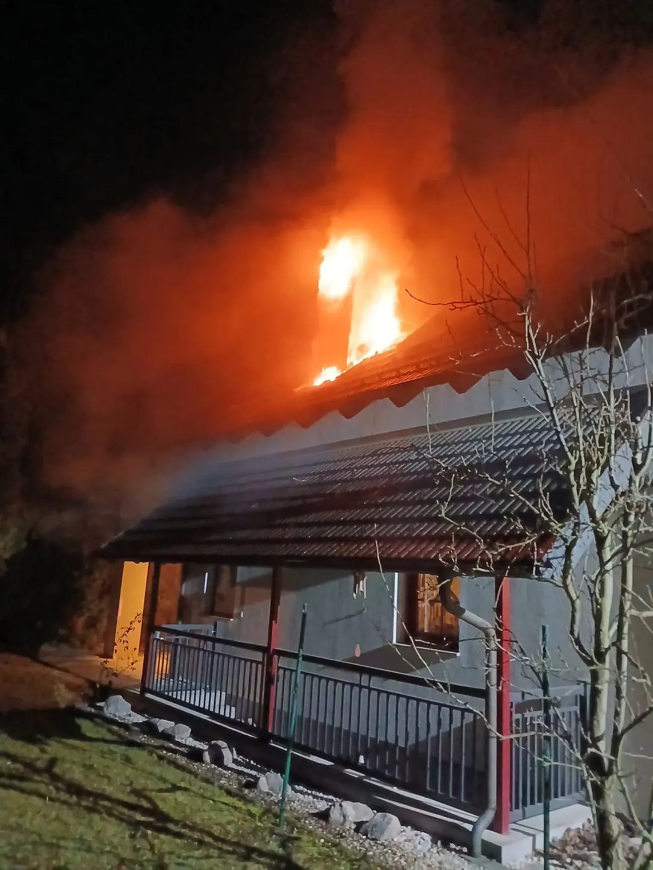 Ein Haus steht nachts in Flammen, mit dickem Rauch. Das Feuer konzentriert sich auf das Dach.