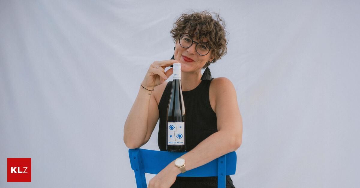 A woman with curly hair and glasses holds a wine bottle with the label 'Make It Matter' on a white background.