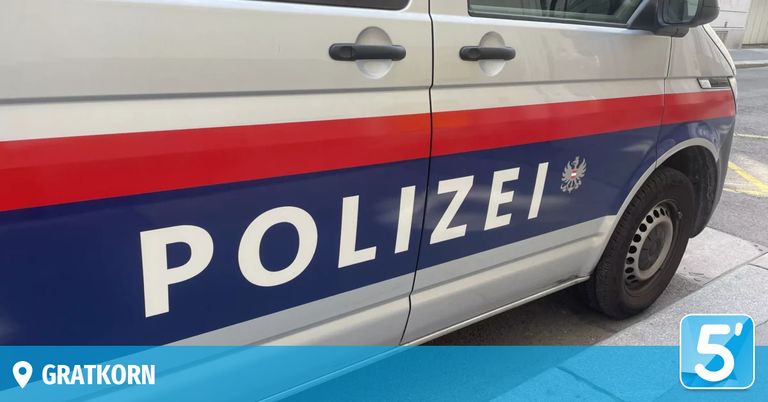 Die Seite eines Polizeiwagens zeigt das Wort Polizei in weißen Großbuchstaben auf blauem Hintergrund, mit roten und weißen Streifen darüber und darunter.