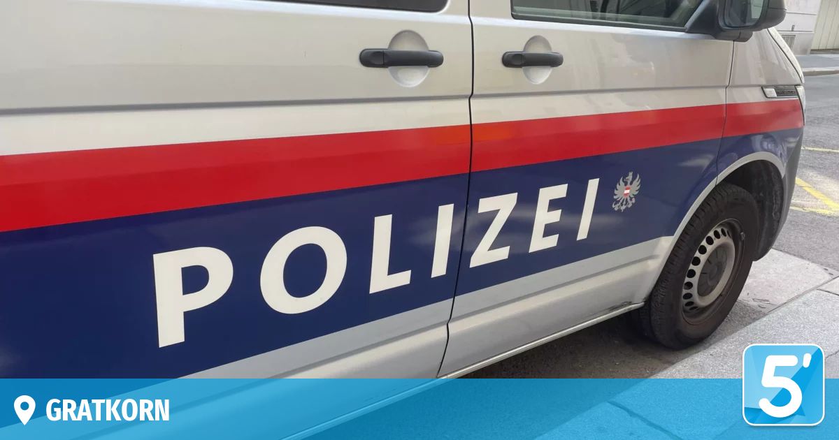 Die Seite eines Polizeiwagens zeigt das Wort Polizei in weißen Großbuchstaben auf blauem Hintergrund, mit roten und weißen Streifen darüber und darunter.