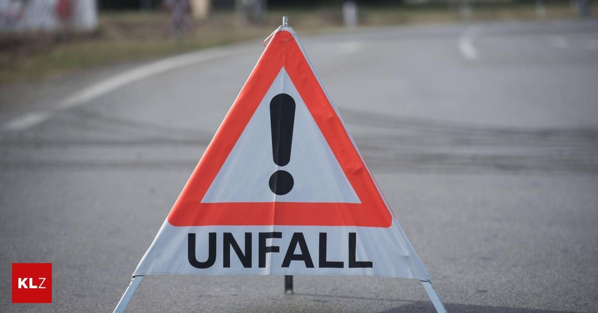 Ein Verkehrsschild mit dreieckiger Form weist auf einen Unfall auf der Straße hin. Das Schild ist weiß mit roten Rändern und enthält den Begriff 'UNFALL' in schwarzen Buchstaben.