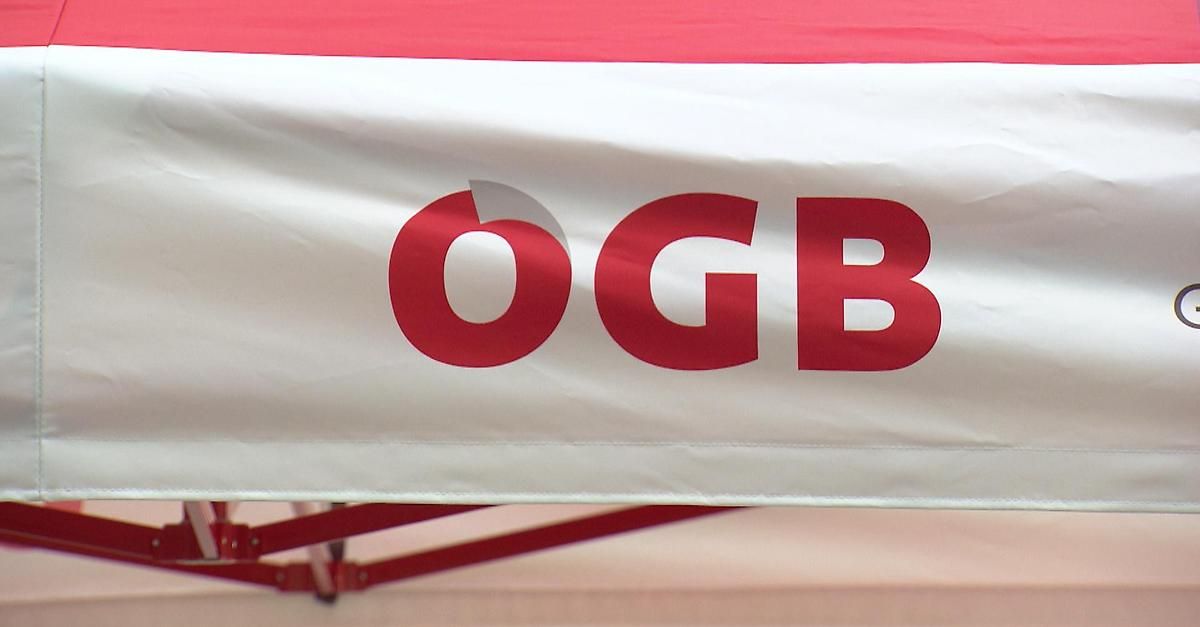 Ein weißes Banner mit roten Buchstaben buchstabiert 'O GB'. Das Banner ist an einem roten Rahmen befestigt.