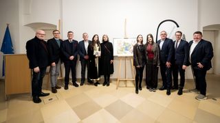 Eine Gruppe von Menschen steht vor einem Gemälde auf einem Staffelei. Sie sind formell gekleidet, und einige halten Bücher. Der Raum hat einen gefliesten Boden und eine weiße Wand.