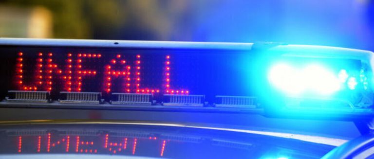 Ein Polizeiauto mit blinkenden blauen Lichtern und einer digitalen Anzeige mit der Aufschrift 'FALL'.