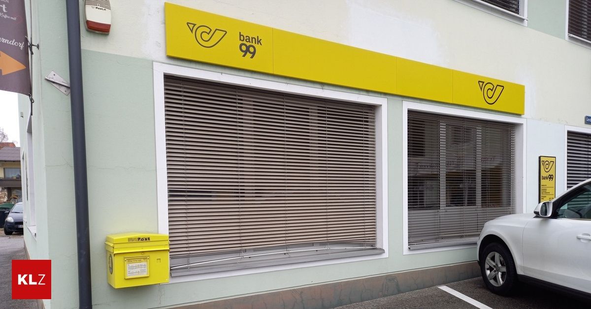 Die Außenseite einer geschlossenen Bank mit einem gelben Schild über den Fenstern. Ein gelber Briefkasten ist an der Wand befestigt.