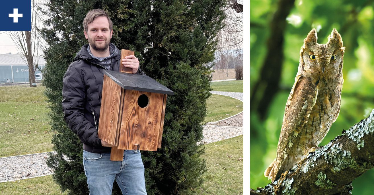 Ein Mann hält ein hölzerne Nistkasten in der Hand und steht neben einem Busch im Garten.