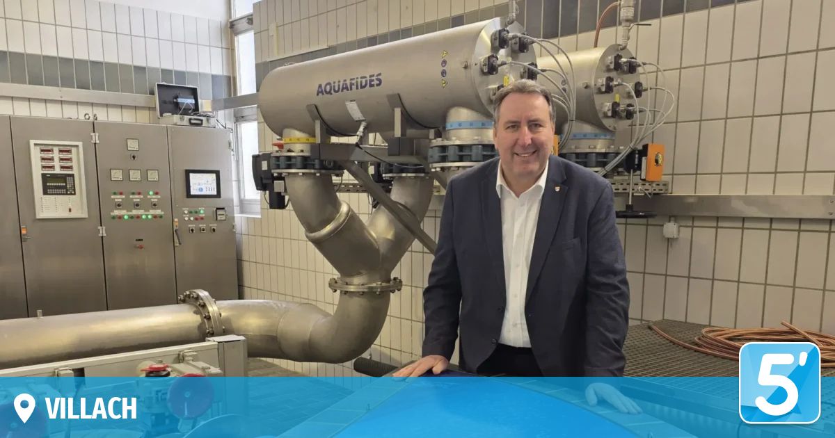 Ein Mann im Anzug lächelt vor einer Aquafides-Filtrationsanlage in die Kamera.