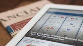 Ein iPad zeigt die Trello-App mit einem geöffneten Artikel zum visuellen Aufgabenmanagement. Der Artikel trägt den Titel '100 von Alison Groves'. Eine Financial Times Zeitung ist im Hintergrund zu sehen.