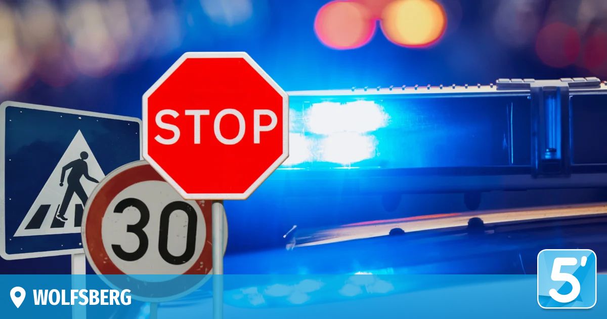 Ein Stoppschild und ein Geschwindigkeitsbegrenzungsschild, 30, auf einem Pfosten mit blinkenden blauen Lichtern im Hintergrund.