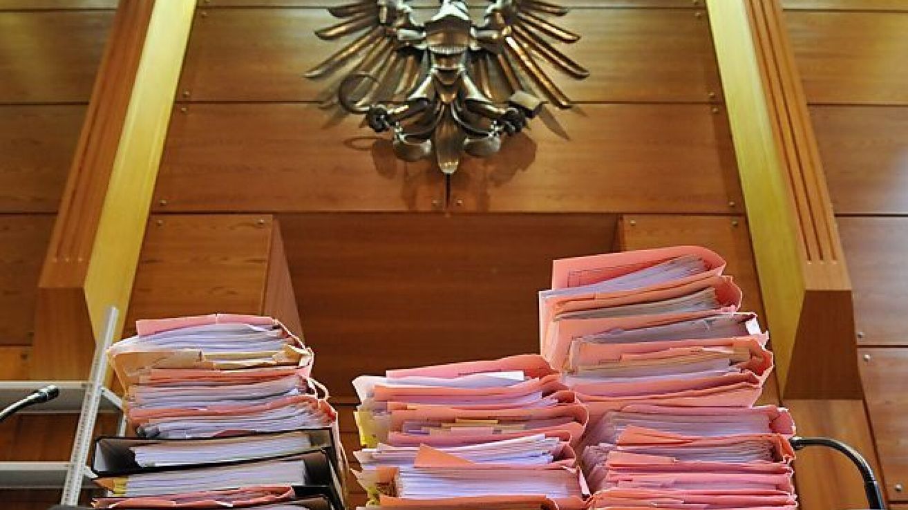 A wooden desk with numerous folders and a large eagle emblem above it. The folders are neatly stacked, and the eagle emblem is intricately designed.