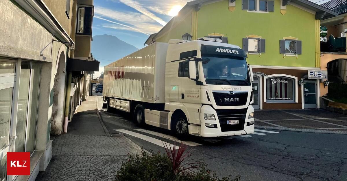 Ein weißer MAN-LKW ist am Straßenrand geparkt, mit einem Berg in der Ferne.