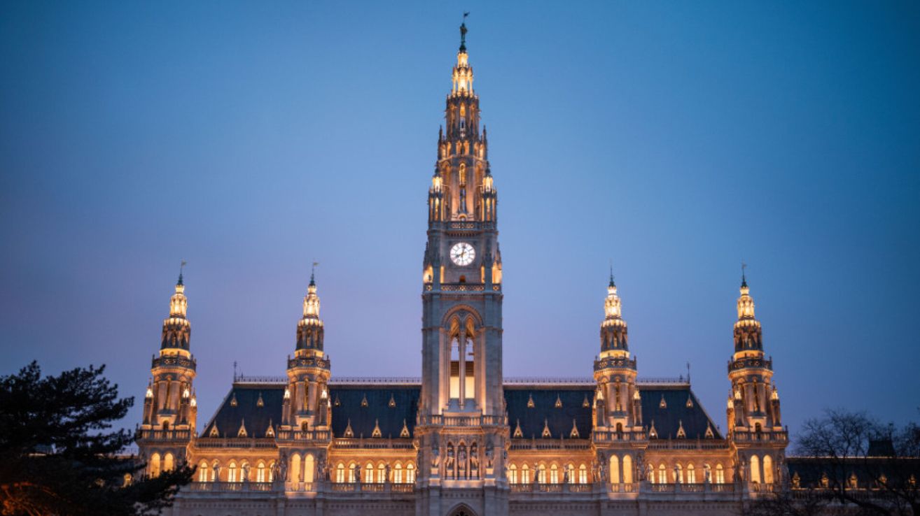 Beleuchtetes Wiener Rathaus mit Glockenturm bei Nacht.