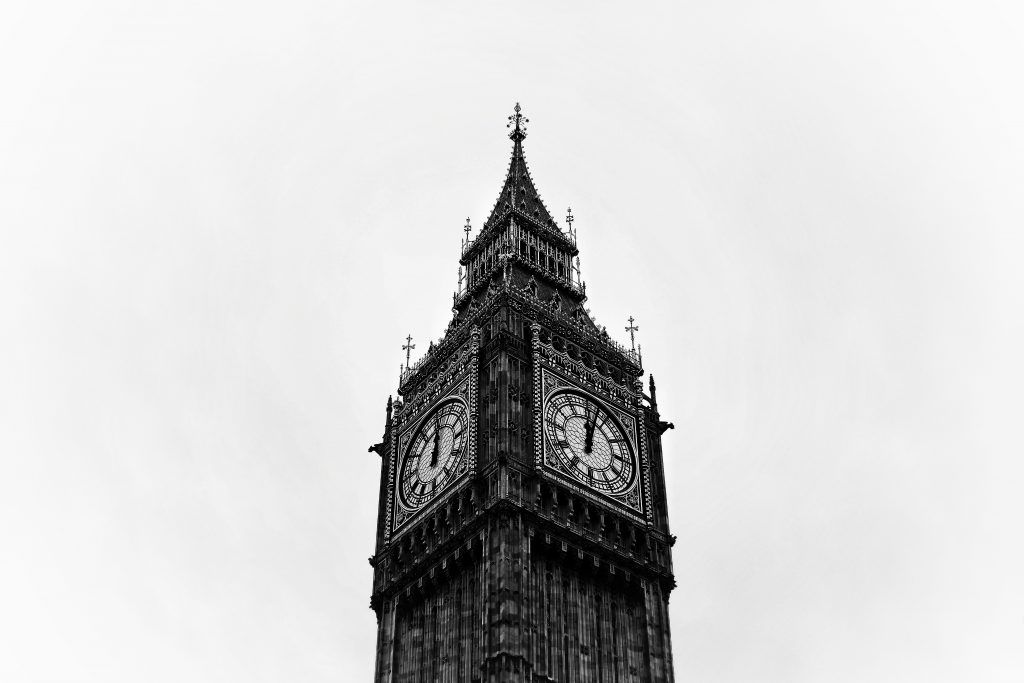 Ein Schwarz-Weiß-Bild des ikonischen Big Ben Uhrturms, das seine komplizierte gotische Gestaltung und zwei große Uhren zeigt.