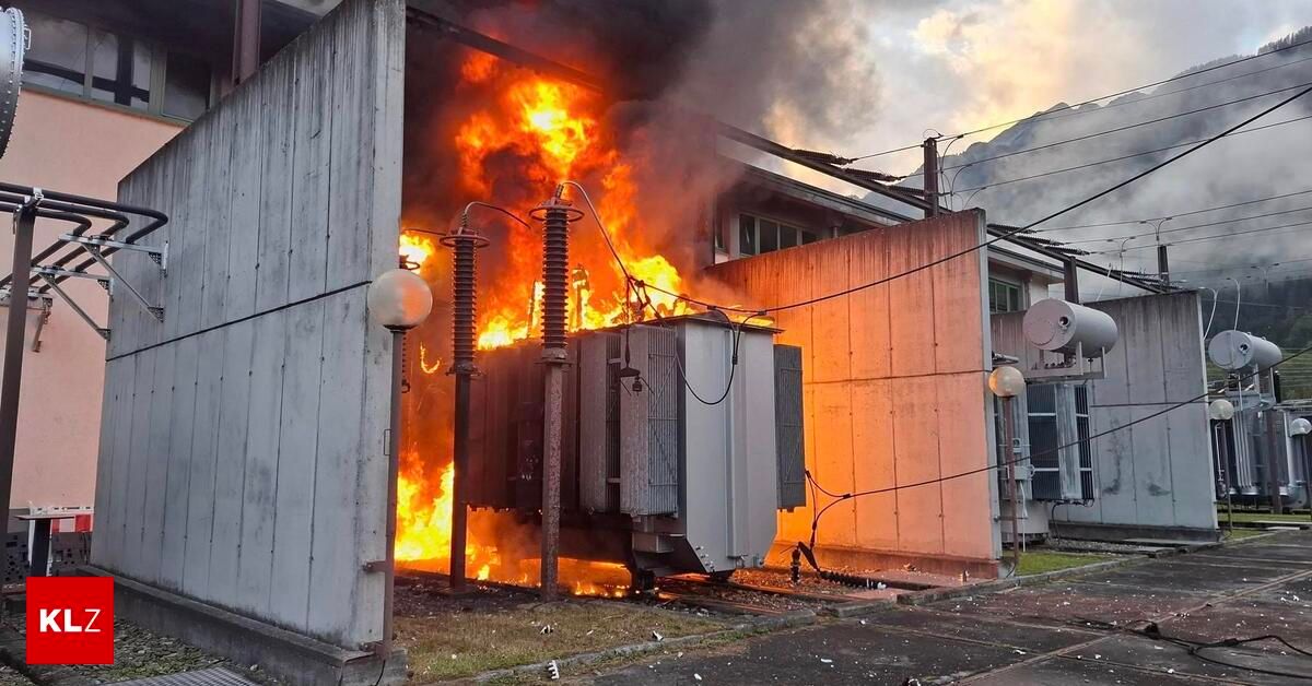 Ein Transformator brennt mit Flammen und Rauch in einem Außenbereich, möglicherweise in einer Industrie- oder Elektrizitätsanlage.