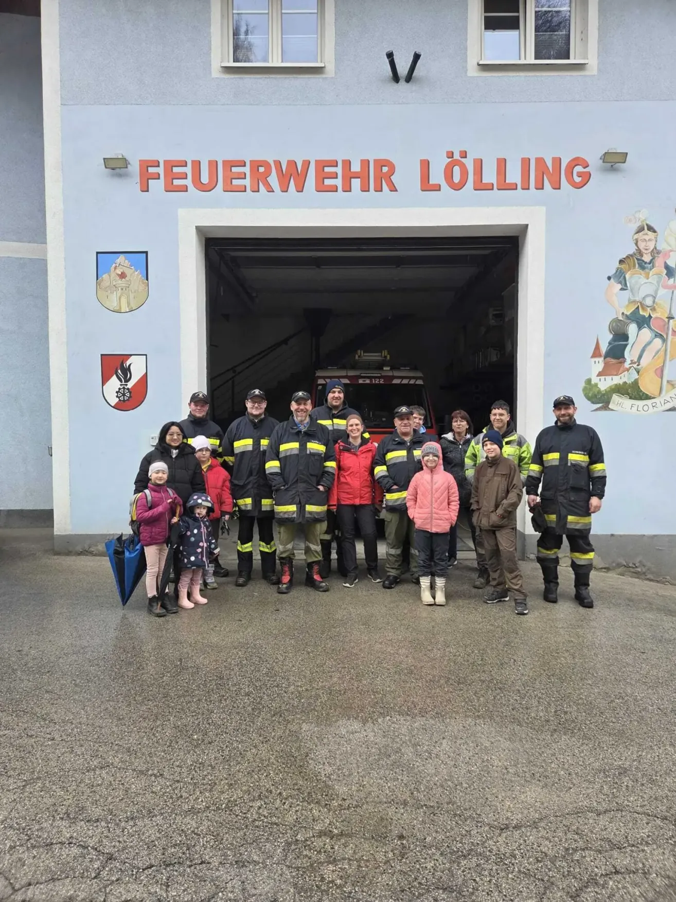 Eine Gruppe von Feuerwehrleuten und Kindern posiert für ein Foto vor der Feuerwache Loelling.