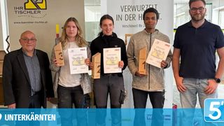 Vier Personen stehen nebeneinander und halten Trophäen. Die Frau auf der linken Seite hält eine Trophäe mit der Nummer drei. Die anderen beiden Frauen halten Trophäen mit den Nummern zwei und eins. Sie lächeln und schauen in die Kamera. Der Mann auf der rechten Seite hält ein Zertifikat.