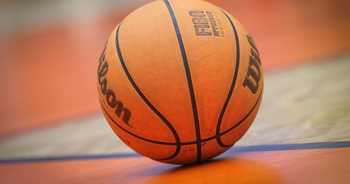 Ein Wilson-Basketball mit dem FIBA-Logo auf einem Holzboden. Der Ball hat eine strukturierte Oberfläche und eine dunkelblaue Naht.