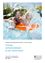 Ein erwachsener Mann und ein Kind sind in einem Pool und spritzen Wasser. Der Mann hält eine orangefarbene Schwimmhilfe, während das Kind in einer blauen Schwimmhilfe ist. Das Bild hat einen Wasserzeichen mit Text am unteren Rand.